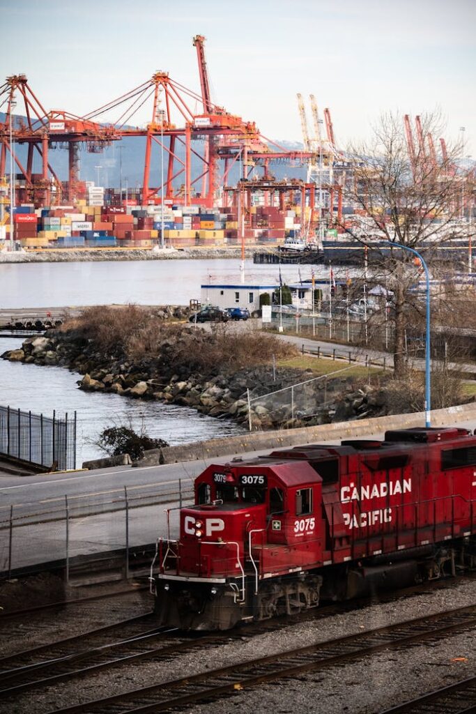 A Canadian Pacific train near container cranes in Vancouver, BC port.